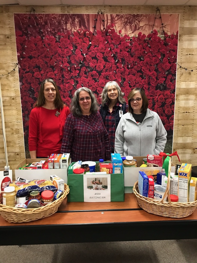 Four women with 5 boxes of food for donations