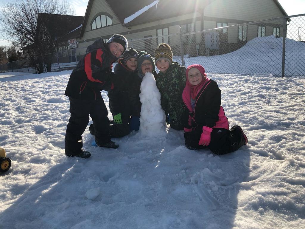 Kids outside around a tower of snow